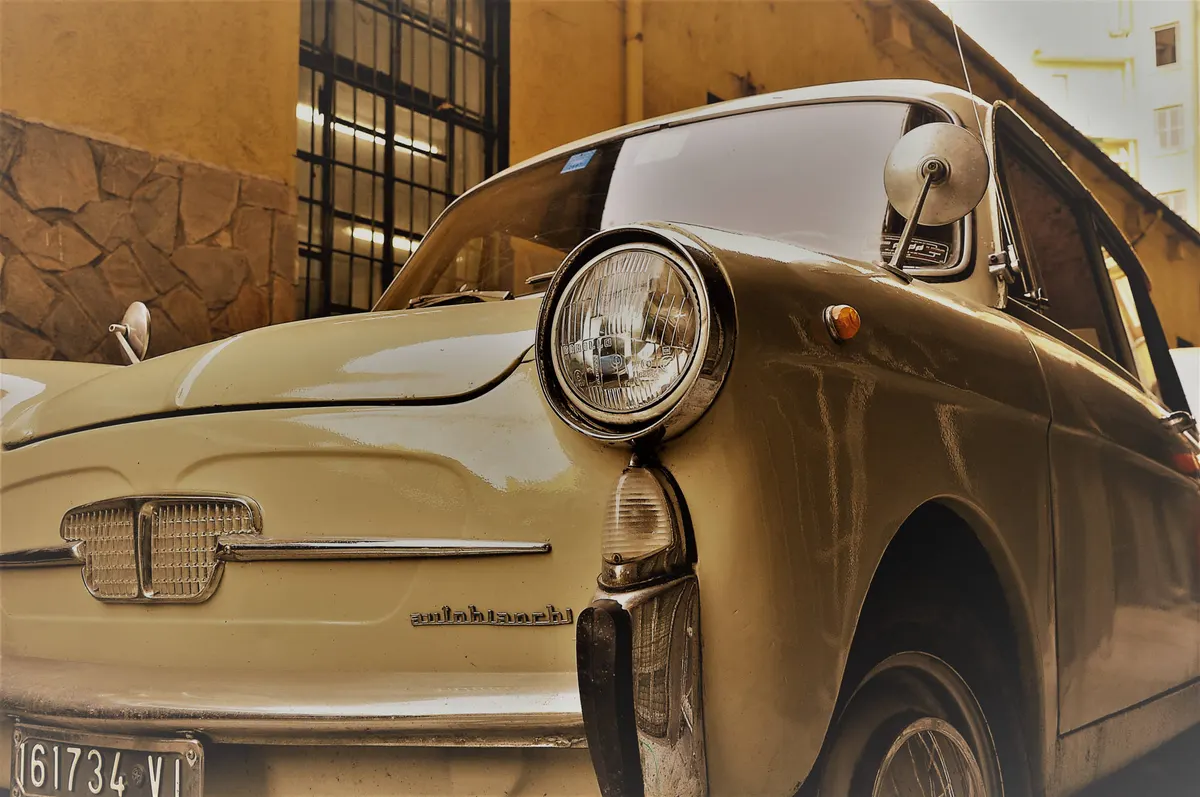 Una piccola utilitaria d'epoca color sabbia